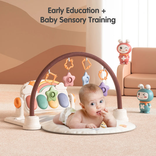 Baby lying on a giraffe-themed play mat under a soft arch with hanging toys, engaging in early education and sensory training activities, with colorful cartoon characters and soft furniture in the background.