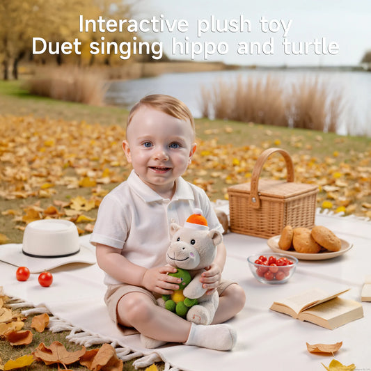 Smiling toddler sitting on a picnic blanket in autumn, holding an interactive plush hippo and turtle toy, with picnic items and lake in the background.