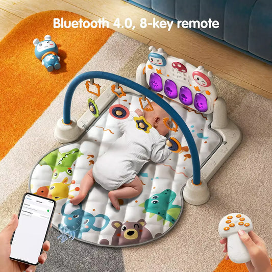 Baby lying on an animal print play gym mat with giraffe, elephant, bear, and dinosaur designs. The gym features a blue arch with hanging rattles and a musical keyboard panel with glowing lights. A smartphone shows Bluetooth 4.0 connection, and a remote control is held in hand.