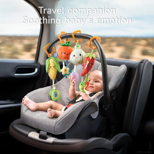 Baby sitting in a car seat playing with colorful plush hanging toys shaped like corn, pumpkin, onion, and chili pepper, designed as a travel companion to soothe baby’s emotions.