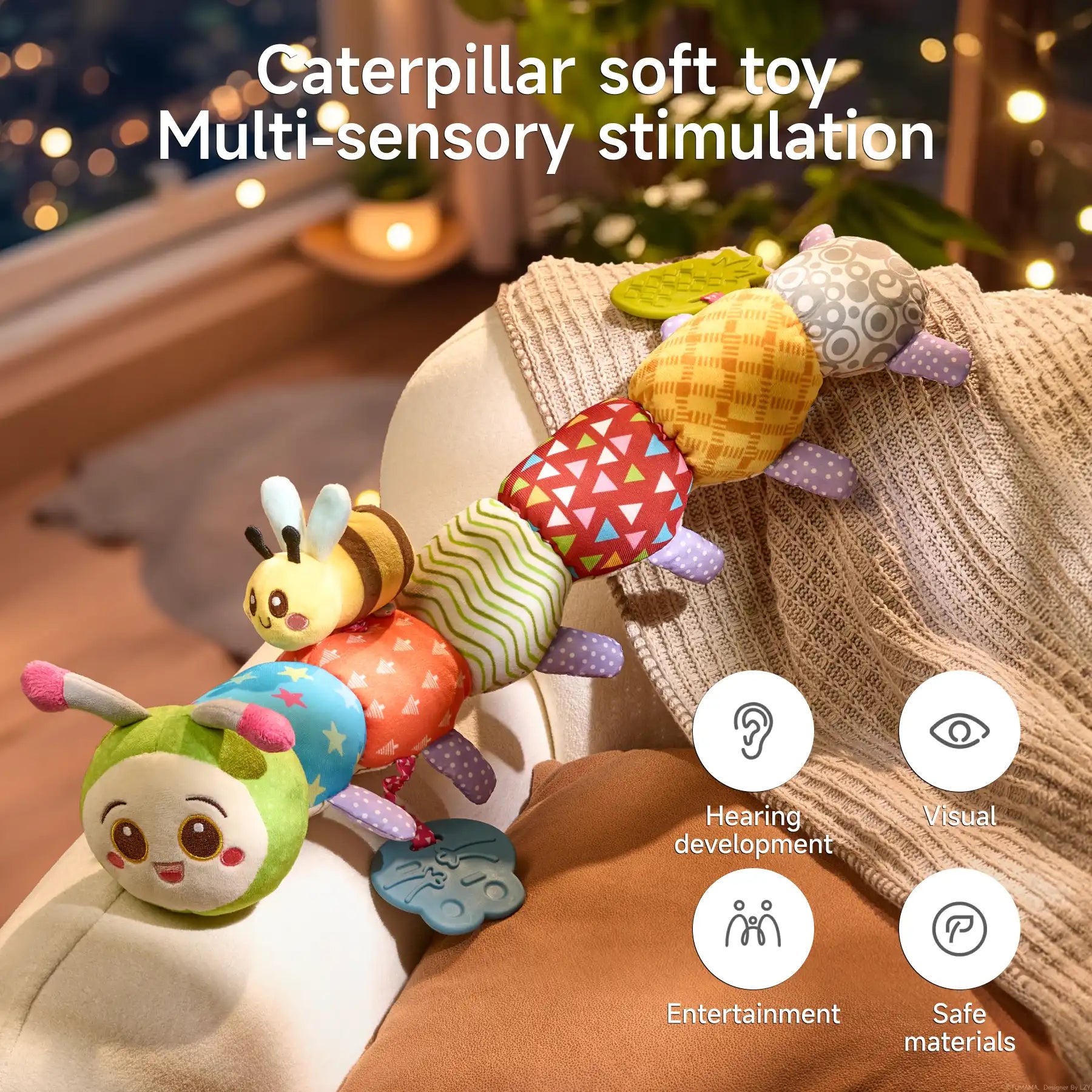 Colorful plush caterpillar toy with attached smiling bee and pineapple teether draped over a sofa arm in a softly lit room, highlighting its multi-sensory benefits for hearing, visual development, entertainment, and safe materials