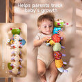 Baby lying in crib holding a colorful plush caterpillar whose underside is printed with measurement markings up to 43 cm to help track infant growth