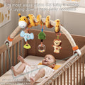 Baby lying in a crib under a plush giraffe arch toy with hanging rattles including elephant with teether, green tree rattle, clear ring with beads, and smiling monkey plush. Arch clips securely to crib sides (fits cribs ≤ 80cm / 31.5 inches), adjustable with min clip 0.4 inch / 1cm and max stretch 2 inches / 5cm. Keeps baby entertained while sitting or lying down.