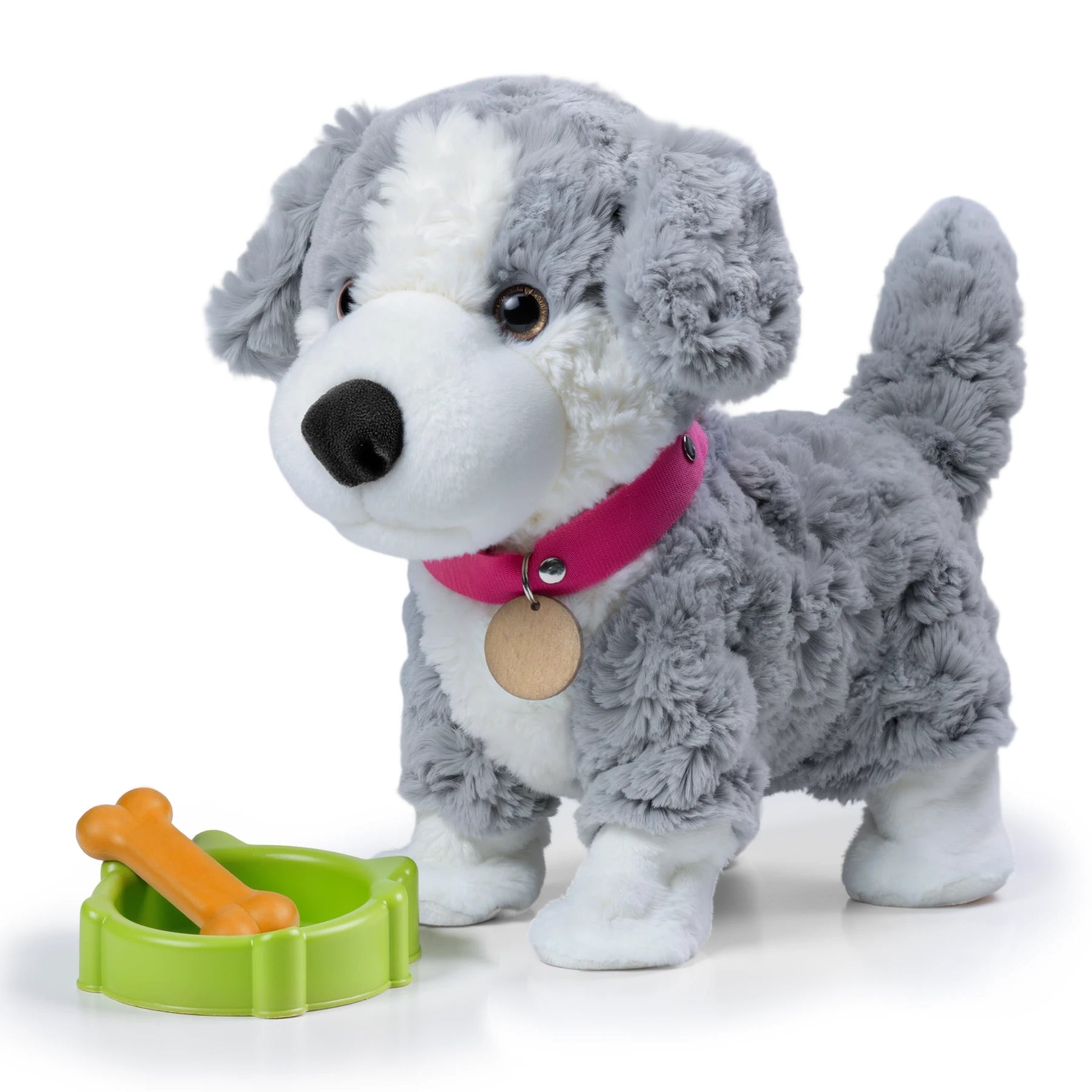 Interactive realistic stuffed toy puppy in gray and white plush with pink collar and tag, standing beside a green dog bowl and orange bone accessory on white background