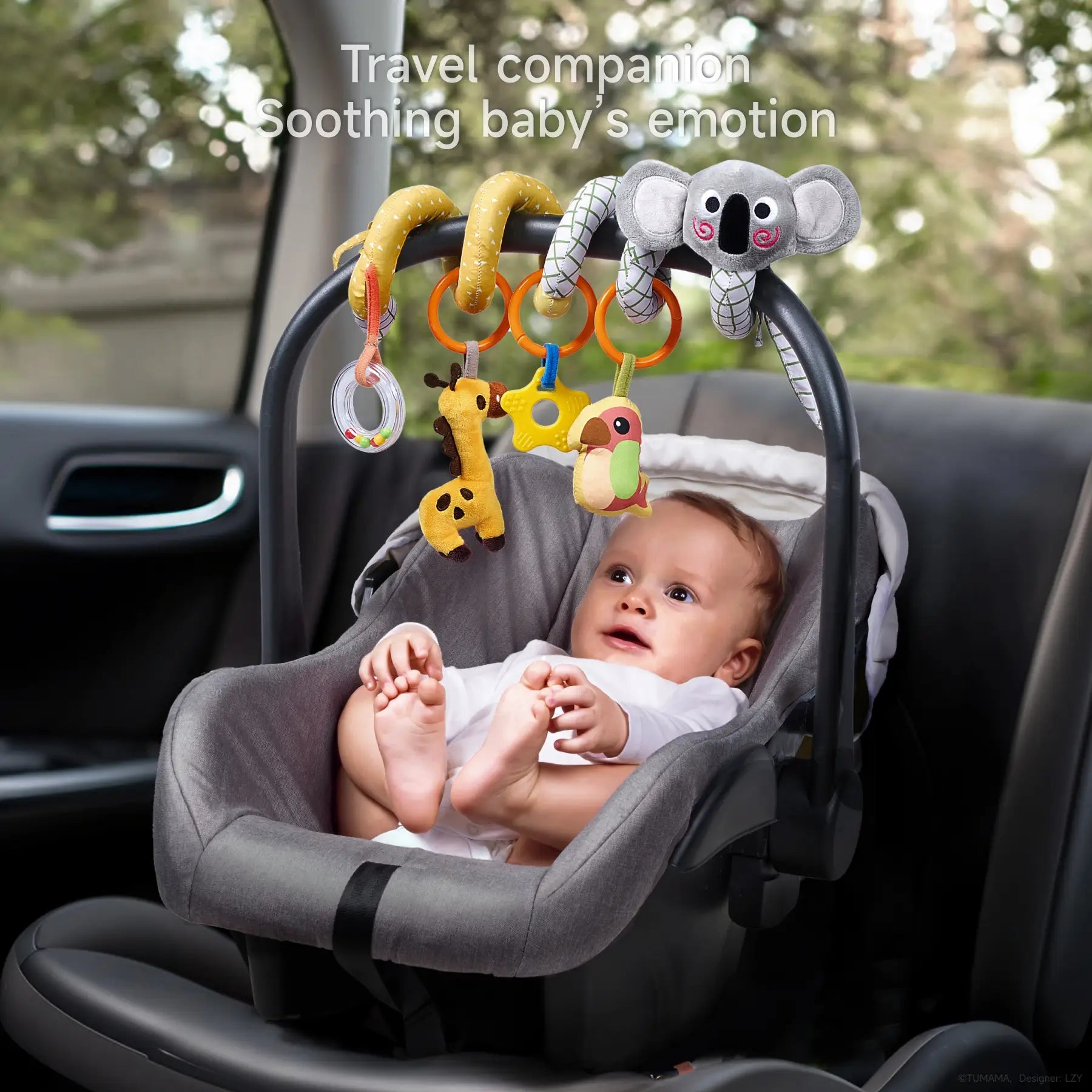 Baby sitting in a car seat, looking up at a koala-themed spiral activity toy wrapped around the handle, with hanging plush toys including a rattle ring, giraffe, star teether, and colorful bird, designed to soothe and entertain during travel.