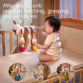 Baby interacting with a colorful bunny spiral toy attached to a crib