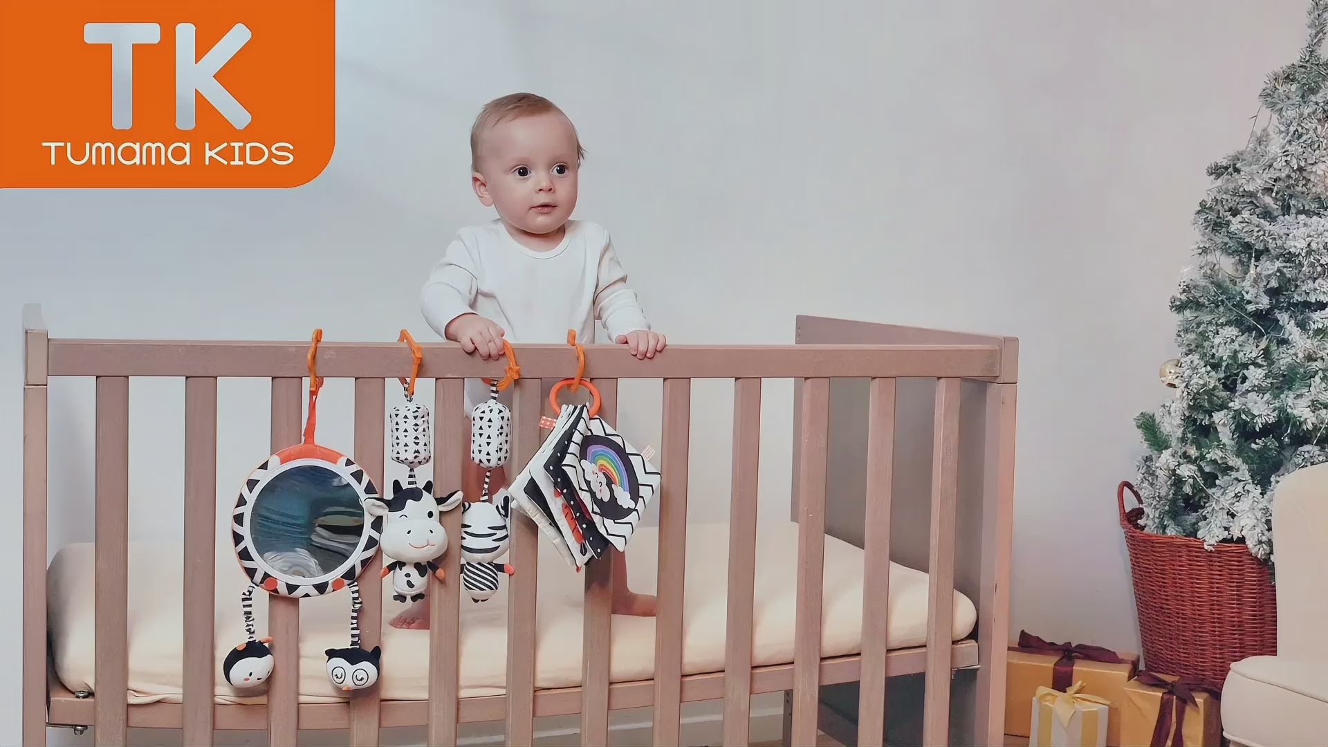 Baby-playing-with-his-black-and-white-plush-toys-in-crib