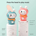 Close-up of two bunny toppers from the baby musical stacking rings toy, one in teal and one in pink. The bases show labeled features including power button, volume controls, speaker, special sound button, and battery cover.