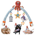 Ocean-themed baby stroller and crib arch toy with blue frame, plush octopus on top, and three hanging toys: striped fish, yellow starfish rattle, and smiling whale with orange star teether.
